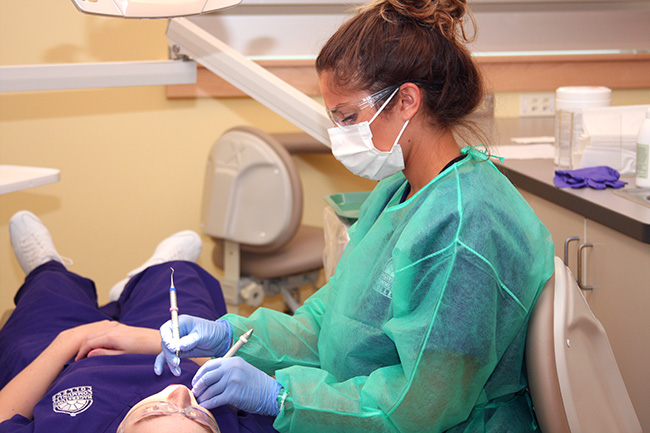 student hygenist works on patient at HCC dental clinic