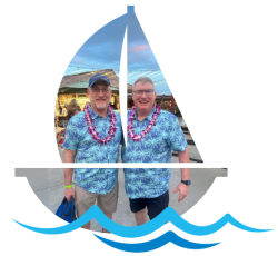 Two Alumni Cruise goers inside a frame the shape of a sailboat