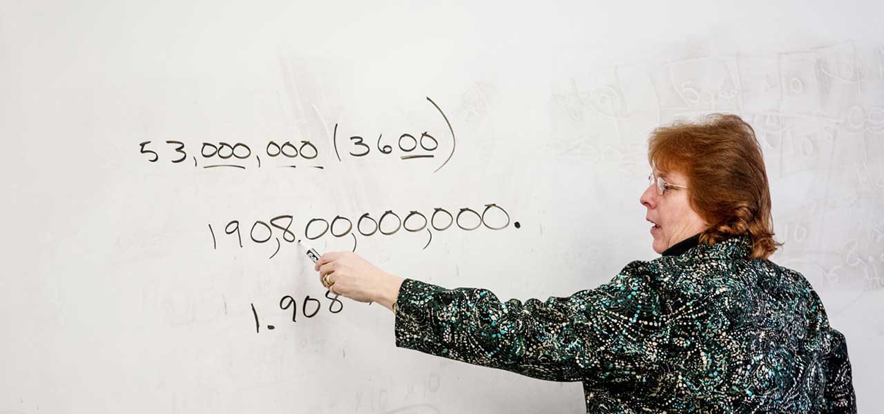 Mathematics teacher doing calculations on a white board