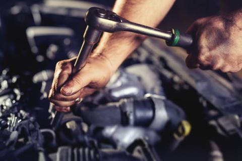 Hands of mechanic working on an engine