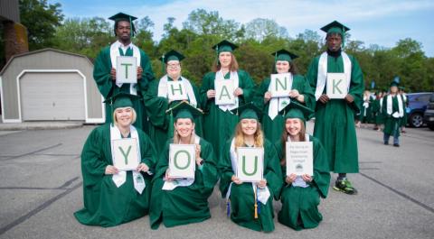 Students at Graduation Holding Signs that spell "Thank You"