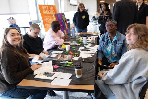 A group of participants sitting around a table doing crafts at the Day of Making